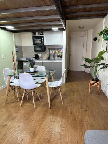 une salle à manger avec une table en verre et des chaises blanches dans l'établissement Mapar Studio en Montevideo, à Montevideo