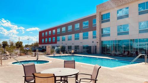 a pool in front of a building with a table and chairs at Holiday Inn Express & Suites Blythe, an IHG Hotel in Blythe