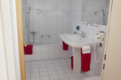 La salle de bains est pourvue d'un lavabo et d'une baignoire. dans l'établissement Kräuterhotel Edelweiss, à Rigi Kaltbad