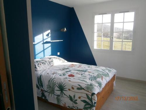 1 dormitorio con 1 cama con pared azul en Gîte Chez Louve Bleue 3 étoiles-Label Tourisme et Hand, en Le Grand-Abergement