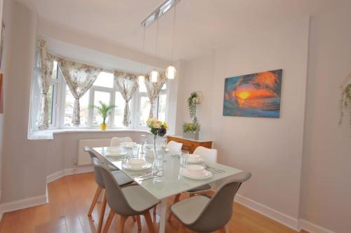 a dining room with a white table and chairs at 3 Bedroom 2 Bathroom Bungalow by CozyNest in Earley