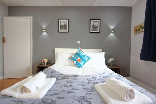 a bedroom with a large bed with towels on it at 3 Bedroom 2 Bathroom Bungalow by CozyNest in Earley
