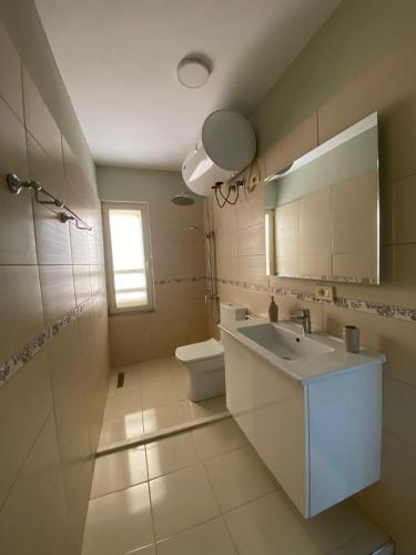 bagno con lavandino, servizi igienici e specchio di Central Park Rooms a Tirana
