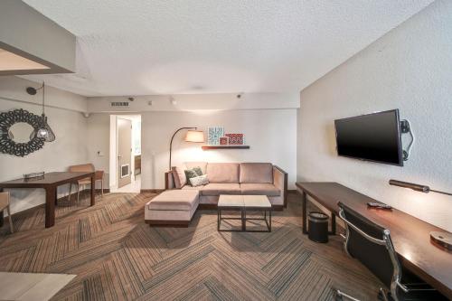 ein Wohnzimmer mit einem Sofa und einem Flachbild-TV in der Unterkunft The Malone in Miami