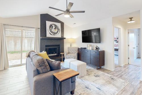 a living room with a couch and a tv at OZK Trail House in Bentonville