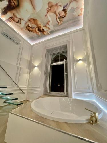 a bathroom with a bath tub with a painting on the ceiling at TOP Luxury Suites in Budapest