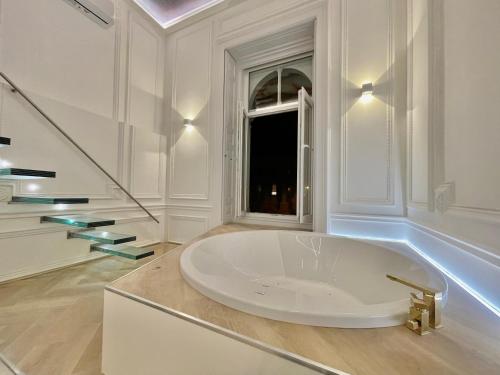 a white bathroom with a large tub and a window at TOP Luxury Suites in Budapest