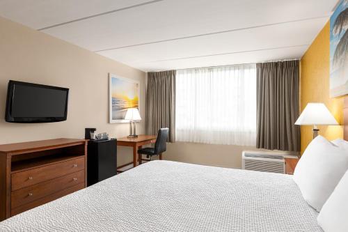 a hotel room with a bed and a desk and a television at enVision Hotel Miami International Airport in Miami