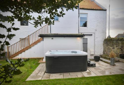 a hot tub in the yard of a house at Newly Renovated early 19th Century Cottage with Hot-Tub in Musselburgh