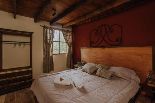 a bedroom with a large bed with towels on it at Cabañas en el Bosque a 5 minutos del mar - Estancia CH in Punta del Este