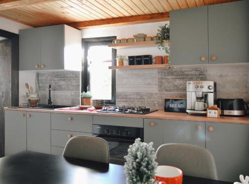 a kitchen with white cabinets and a table with chairs at Cuib din Fagaras in Avrig