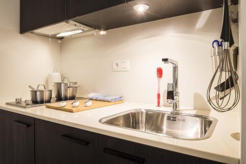 a kitchen counter with a stainless steel sink at Getaway Studios Leuven in Leuven