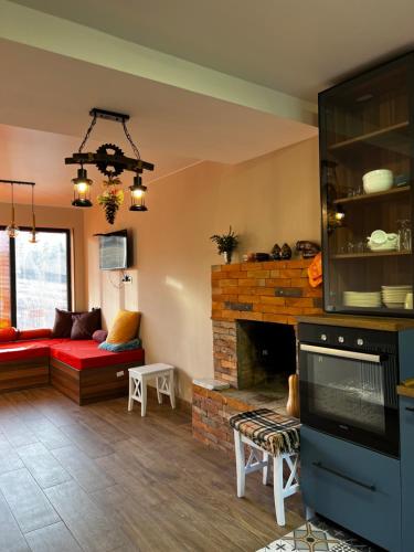 a living room with a fireplace and a red couch at 3 Cottage Near The Forest in Bakuriani