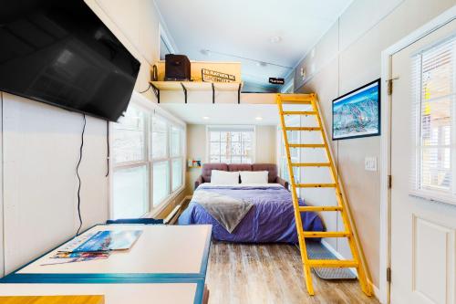 a tiny bedroom with a bunk bed and a yellow ladder at Tiny Homes on Pleasant in Ludlow