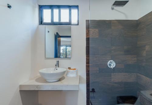La salle de bains est pourvue d'un lavabo et d'une douche. dans l'établissement Hotel Mody Merida, à Mérida