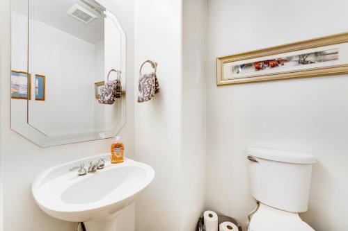 a white bathroom with a toilet and a sink at Roy Rogers Poolhouse in Cave Creek