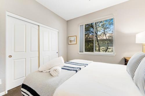 a white bedroom with a bed and a window at Roy Rogers Poolhouse in Cave Creek