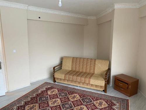 a living room with a chair and a rug at Sefam konaklama in Erzurum