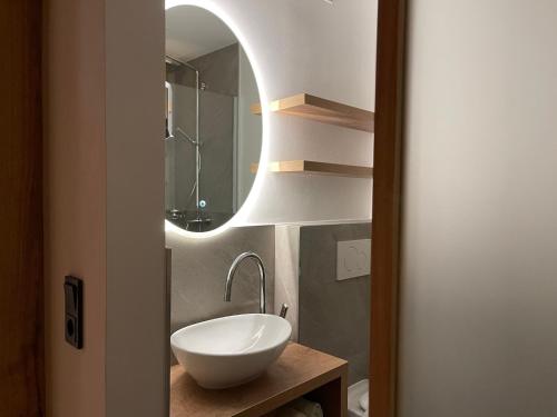 a bathroom with a white sink and a mirror at Heutaler Hof - Hotel im Naturidyll in Unken