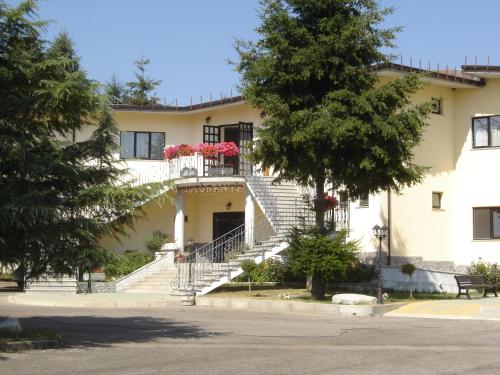 a white building with stairs and flowers on it at Hotel La Fattoria in Camigliatello Silano