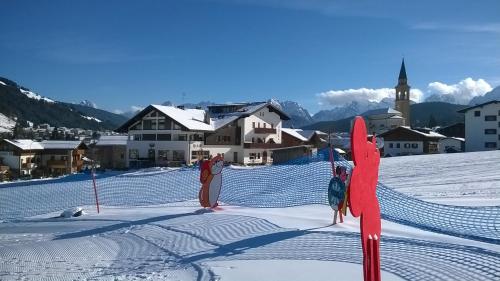 un grupo de personas de pie en la cima de una pendiente cubierta de nieve en Hotel D'La Varda, en Padola