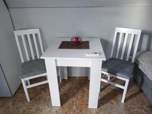 a white table with two chairs and a bowl on it at Yellow story in Vrdnik