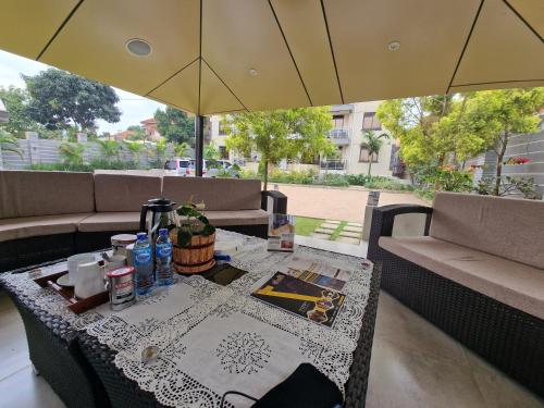 a table with an umbrella on a patio at Eric Wilkins Apartments in Kampala