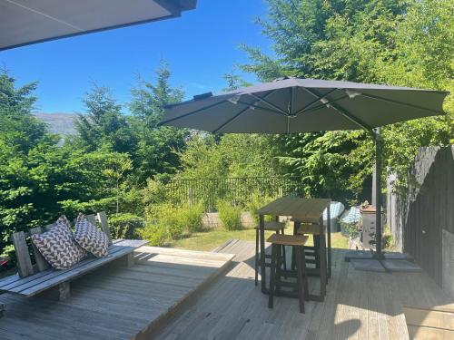 een patio met een tafel en een parasol bij Private Retreat Central Wanaka 2 Bedroom in Wanaka