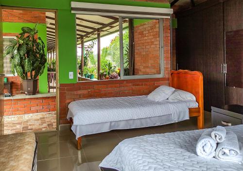 a bedroom with two beds and a window at Finca Hotel el Vergel Filandia Quindio in Filandia