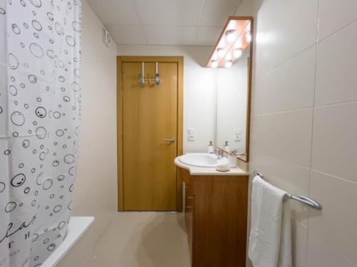 een badkamer met een wastafel en een houten deur bij Apartamento Delta in Deltebre