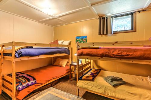 a room with three bunk beds and a window at Riverside Winthrop Chalet with Hot Tub and 2 Decks! in Winthrop