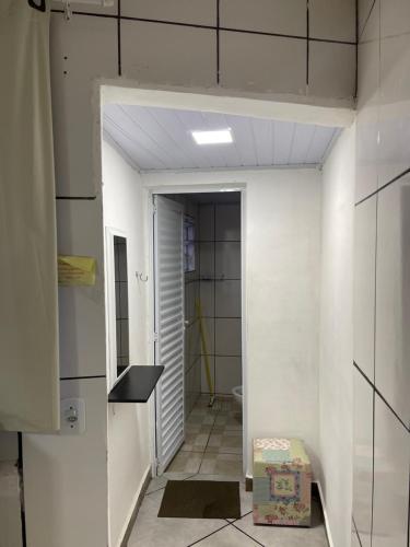 a hallway with a door to a bathroom with a toilet at BERTIOGA suítes na praia centro in Bertioga