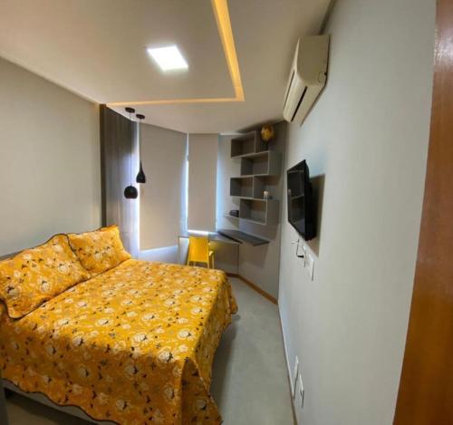 1 dormitorio pequeño con 1 cama y TV en Excelente localização na Barra -Climatizado-Garagem, en Salvador