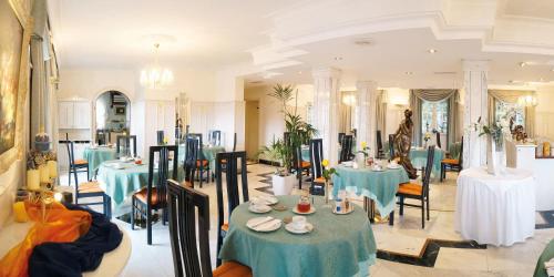 a dining room with blue tables and chairs at Hotel Sacher-Stoiber in Bad Füssing