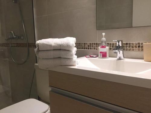 een badkamer met een wastafel, een toilet en handdoeken bij Apto Península excelente ubicación** in Punta del Este