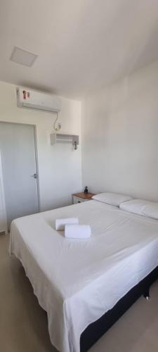 a white room with a large bed with white sheets at Pousada Litorânea in São Luís