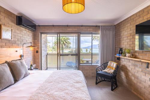 a bedroom with a bed and a view of the ocean at Bermagui Beach Hotel in Bermagui