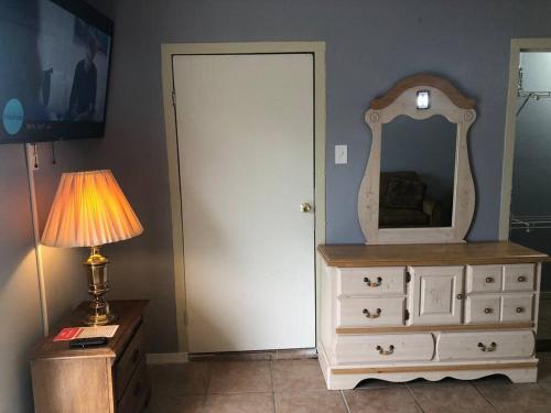 a room with a dresser and a mirror and a lamp at A Smaller Piece of Heaven, Near by Lackland AFB in San Antonio