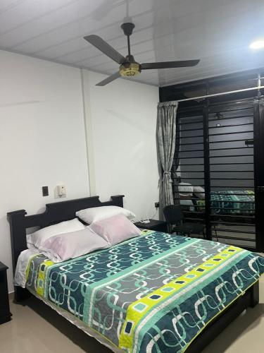 a bedroom with a bed and a ceiling fan at Hotel RIO Y SOL DORADO in La Dorada
