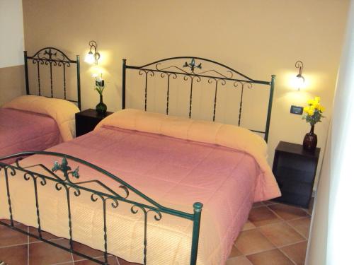a bedroom with two beds with pink and white sheets at Agriturismo Il Pozzo Antico in Mascali
