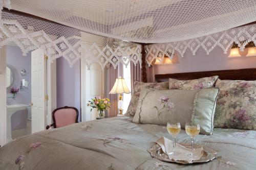 a bedroom with a bed with two glasses of wine at The Tower Cottage Bed and Breakfast in Point Pleasant Beach