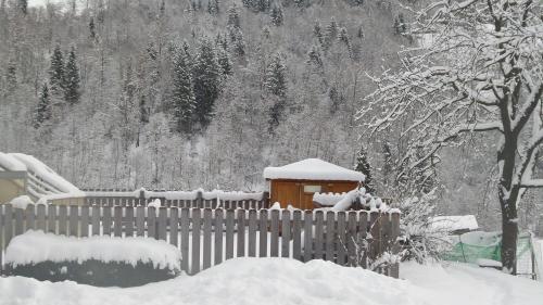 a fence covered in snow next to a house at Pension Schwaighof in Oberau