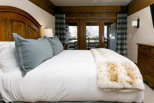 a bedroom with a white bed with a wooden headboard at Deluxe King Room with Deck Hotel Room in Park City