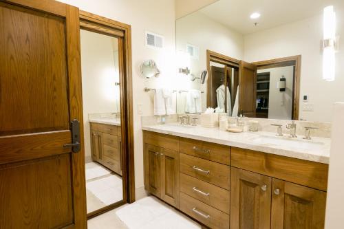a bathroom with two sinks and a large mirror at Deluxe King Room with Deck Hotel Room in Park City