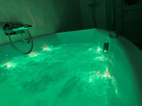 a bathroom with a tub filled with blue water at Plus haut jacuzzi d’Europe, 40e étage in Puteaux