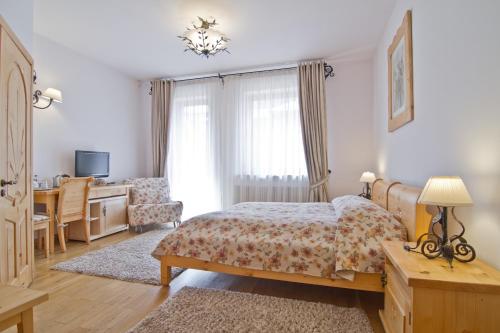a bedroom with a bed and a desk and a chair at Willa Kominiarski Wierch in Zakopane