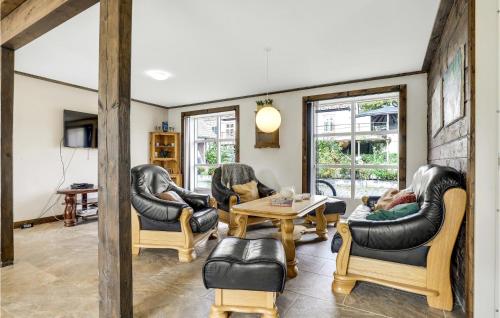 a living room with leather chairs and a table at 6 Bedroom Cozy Home In Gudhjem in Gudhjem