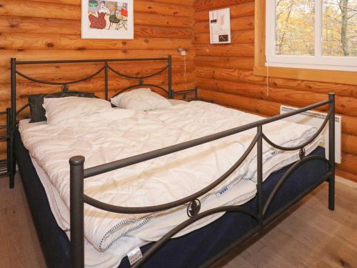 1 dormitorio con 1 cama en una cabaña de madera en Holiday home Hadsund XLIV en Odde