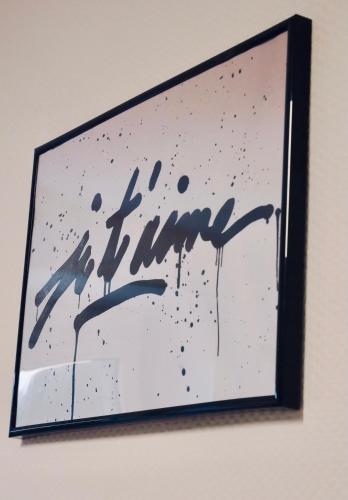 a painting of the word time hanging on a wall at Le nid douillet de Sarreguemines in Sarreguemines