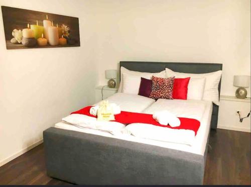 a bedroom with a large bed with red and white pillows at INN JOY Apartments - Rorschach mit Panoramasicht in Rorschach